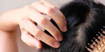 Women touching scalp with brush and hand